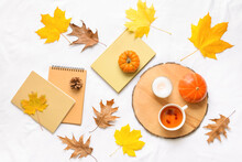 Beautiful Autumn Composition With Cup Of Tea And Book On White Fabric Background