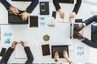 © xartproduction - Group of young business people working and communicating while sitting at the office desk together with colleagues sitting. business meeting. Desktop top view.