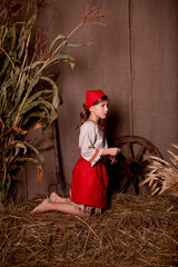 Wall Mural - little girl in a light linen shirt and a red scarf in a rustic style