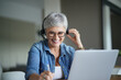© goodluz - Mature woman with grey short hair working from home during pandemia
