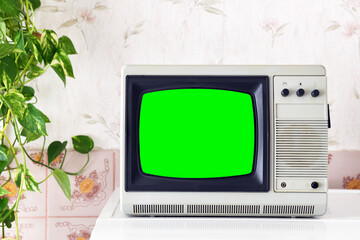 Retro TV in a green screen room with vintage wallpaper in the style of the 1980s 1990s.
