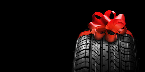 Wall Mural - a black isolation rubber tire, on the grey backgrounds in a bow for christmas