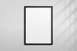 © Omeris - Mockup black frame photo on wall with shadow. Mock up artwork picture framed. Vertical boarder. Empty board a4 photoframe. Modern 3d border for design prints poster, blank, painting image. Vector