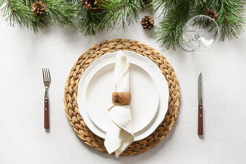 Christmas table setting with white holiday elegant decorations on white table. View from above.