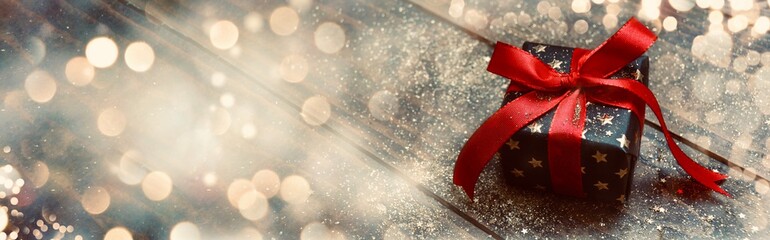 Wall Mural - gift box with gold stars and red bow on wooden background with bokeh lights - christmas background b