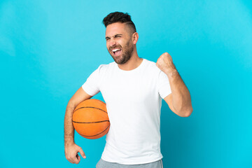 Caucasian man isolated on blue background playing basketball