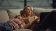 © stockbusters - Mom using laptop next to daughter on couch. Girl falling asleep mom shoulder