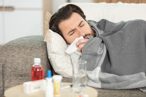 Fotografía sick man with flu lying in sofa at home