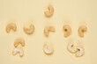 Creative layout made of cashew. Flat lay. Food concept. Cashew on light yellow background