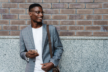 Poster - Happy african american man using mobile phone while standing