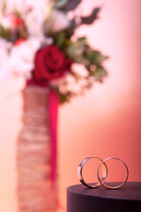 Two wedding rings on the background of a defocused trendy wedding bouquet. background for romantic design for valentine's day, wedding invitations