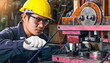 © atitaph - Asian male worker In industries that wear glasses, safety hats and safety uniforms Wrench tool holder stand