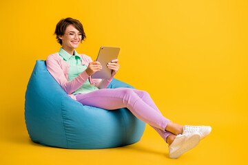 Wall Mural - Full length body size photo female student glasses using tablet reading article in internet isolated on vibrant yellow color background