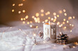 © Floydine - Natural Christmas decoration with burning candle on white linen and pine cones  -  magic lights in background