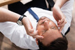 © LIGHTFIELD STUDIOS - Top view of businessman with migraine, holding hands on temples on blurred background