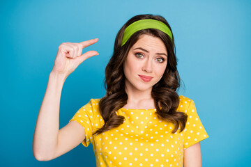 Sticker - Photo of frustrated girl show little object empty space size with hands isolated over blue pastel color background