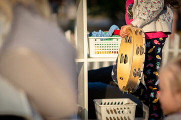 The child beats the tambourine. Child learning to play musical instruments