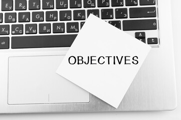 Poster - laptop with memo sticks on the keyboard with text objectives on it.