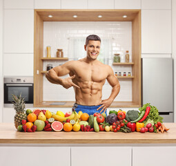 Sticker - Topless muscular young man showing his muscles and posing in a kitchen