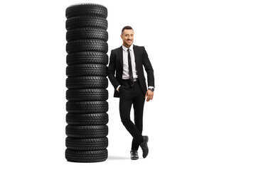 Poster - Full length portrait of a young businessman leaning on a pile of tires