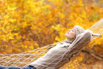 Wall Mural - Relaxed woman lying on hammock in autumn forest