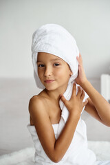 Cute girl wearing a bathrobe with wet hair after bath or shower, laughing and smiling.