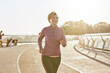 © Kostiantyn - Improving health. Portrait of happy motivated mature woman in sportswear running outdoors on a sunny day