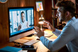 © insta_photos - Caucasian business man talking with african male partner coach on video conference call discussing social distance work at virtual remote meeting videoconference chat using pc computer at home office.
