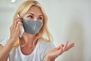 Middle aged caucasian woman talking on phone at home