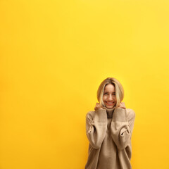 Sticker - Beautiful young woman wearing knitted sweater on yellow background. Space for text