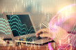 © peshkova - Double exposure of man's hands holding and using a digital device and forex graph drawing. Financial market concept.