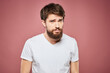 © SHOTPRIME STUDIO - emotional man white t shirt sad facial expression pink background