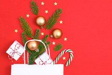 Paper Bag On Red Background. With Gift Box, Balls, Christmas Tree Christmas Gift Preparation Concept.