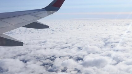 Wall Mural - wing of an airplane flying above the clouds. Travel concept