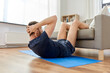 © Syda Productions - sport, fitness and healthy lifestyle concept - man making abdominal exercises at home