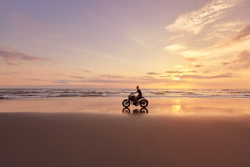 Man And Motorcycle On Ocean Beach At Beautiful Tropical Sunset. Biker’s Silhouette On Motorbike On Sandy Coast Near Sea In Bali, Indonesia.