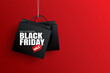 © kaisorn - Black friday sale with black shopping bag and the rope hanging on red background