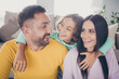 © deagreez - Photo of full family three people small boy embrace parents shiny smile wear colorful pullover in living room indoors