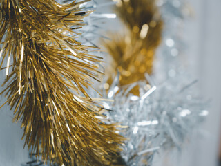 Wall Mural - Golden and silver  tinsel, Christmas ornament on yellow background background.Golden and silver  tinsel, Christmas ornament over white background.