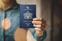 Man Wearing Blue Jeans Shirt And Showing Saint Lucia Passport. Blurred Background. Horizontal Mockup