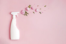 Plastic Bottle With Cleaning Spray And Flowers On Pink Background.