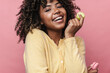 © Drobot Dean - Happy african american woman smiling while posing with macaroons