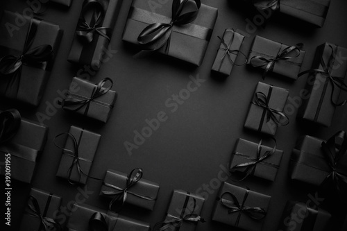 Cuadros en Lienzo Arranged Gifts boxes wrapped in black paper with black ribbon on black background