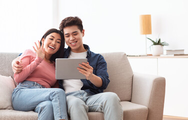 Wall Mural - Chinese Couple Making Video Call Via Digital Tablet At Home