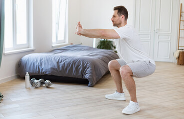 Aufkleber - Sporty Guy Doing Two-Legged Squat Exercise At Home