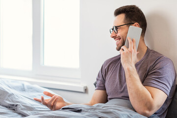 Aufkleber - Happy Man Talking On Mobile Phone Sitting In Bedroom