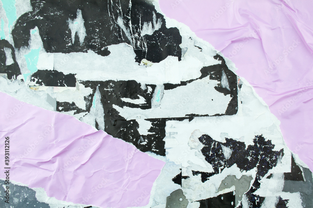 Torn black and purple posters glued on billboard with old dirty peeling ...