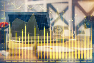 Financial graph colorful drawing and table with computer on background. Double exposure. Concept of international markets.