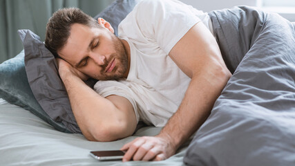 Aufkleber - Man Sleeping Holding Smartphone Lying In Bed Indoor, Panorama