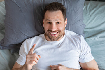 Aufkleber - Guy Having Idea Pointing Finger Up Lying In Bed, Top-View